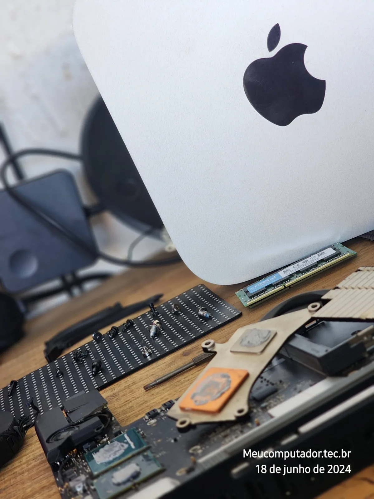 Notebook aberto para manutenção, com dissipador e pasta térmica sendo trocados na bancada da meucomputador